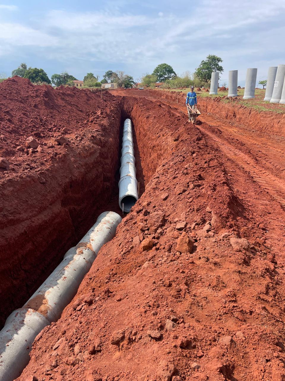 Transporte de tubos de concreto até a vala de drenagem