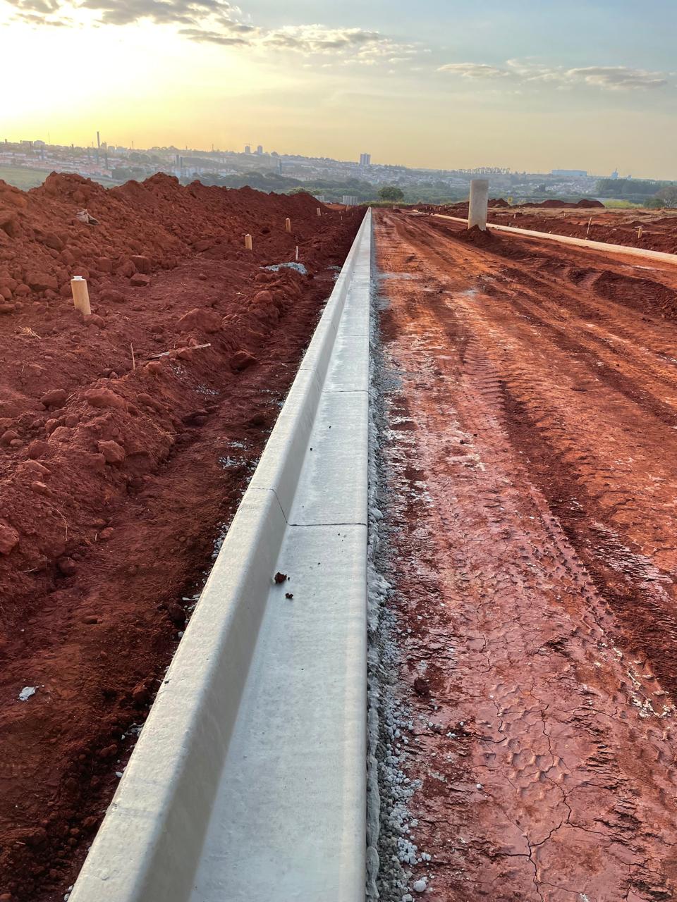 Guia e sarjeta instaladas em via de loteamento ao entardecer